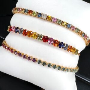 Pulsera “tennis” con zafiros de colores y diamantes en oro amarillo.